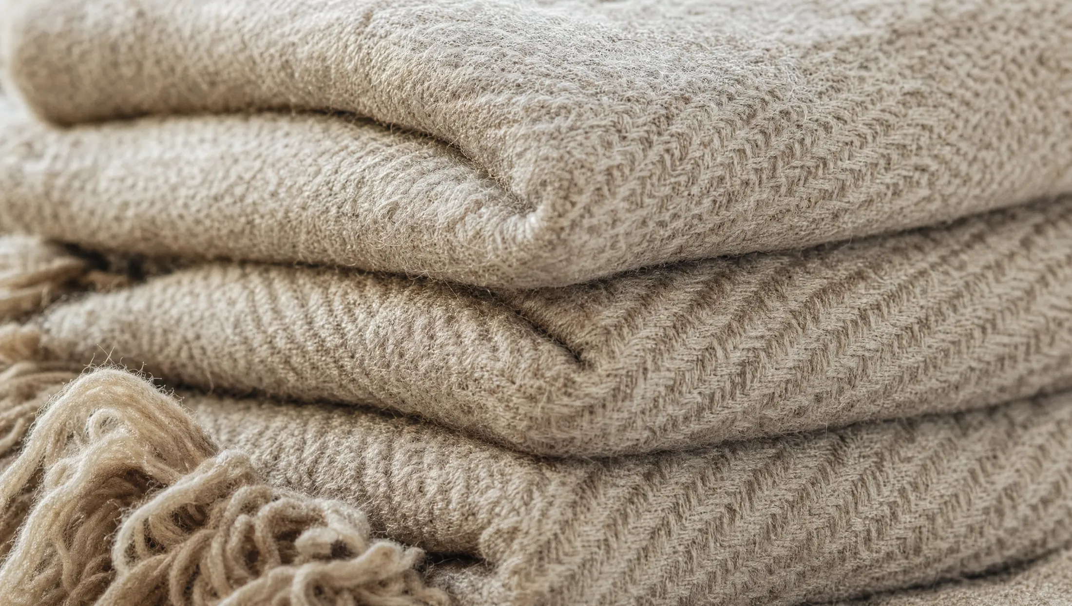 Folded oatmeal herringbone wool throws